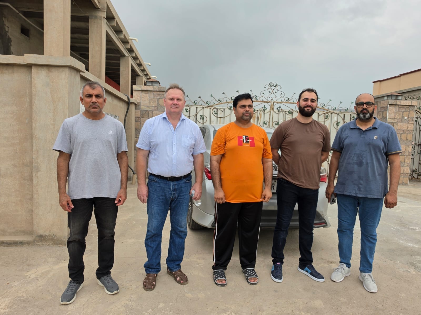 Five-member group photo of H&N International representatives and Chairman Chicks team outside the breeder farm
