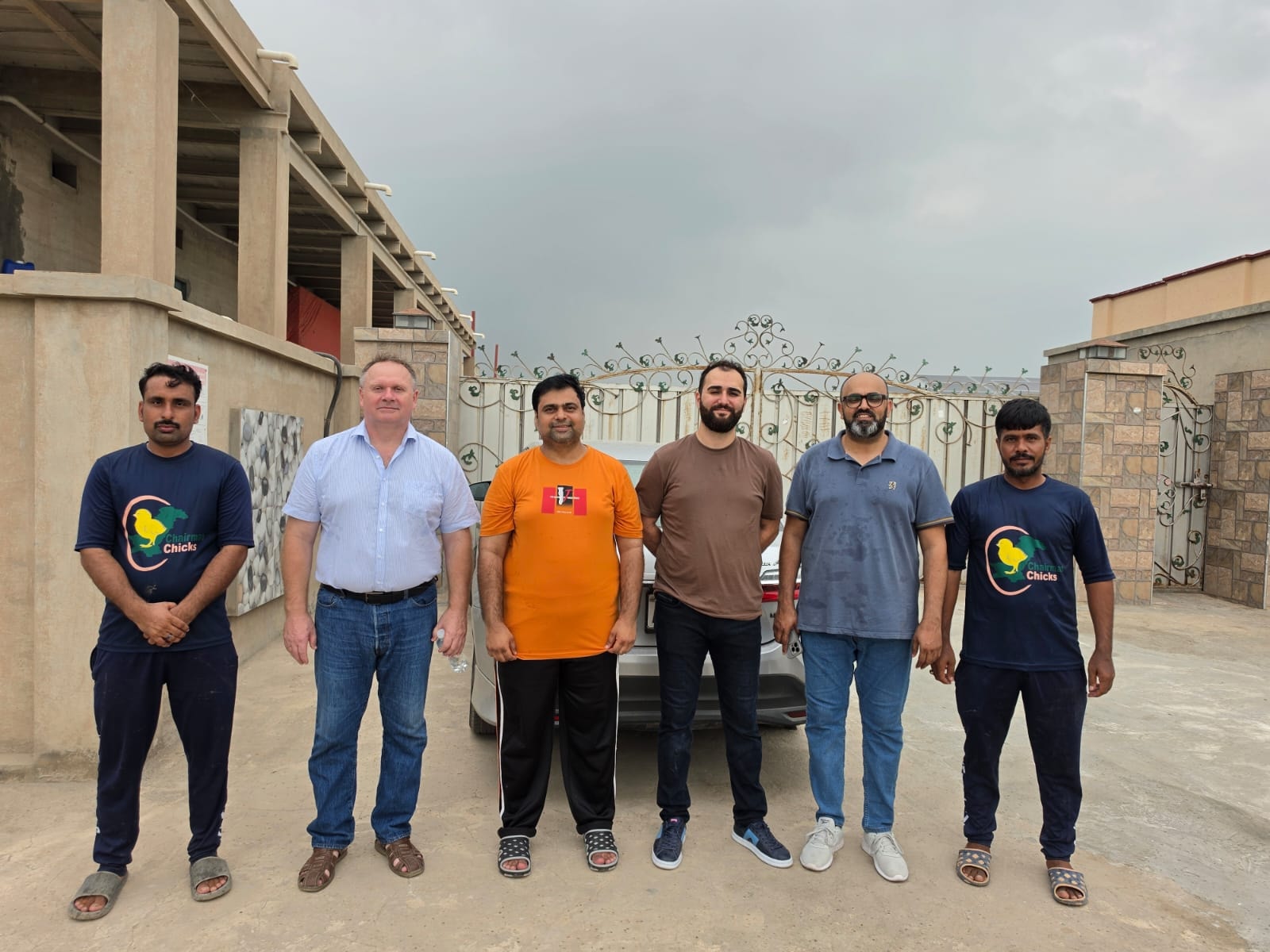 Dr. Mikhail Malyshev and Dr. Yigithan Taskin with Chairman Chicks team of six outside the breeder farm facility