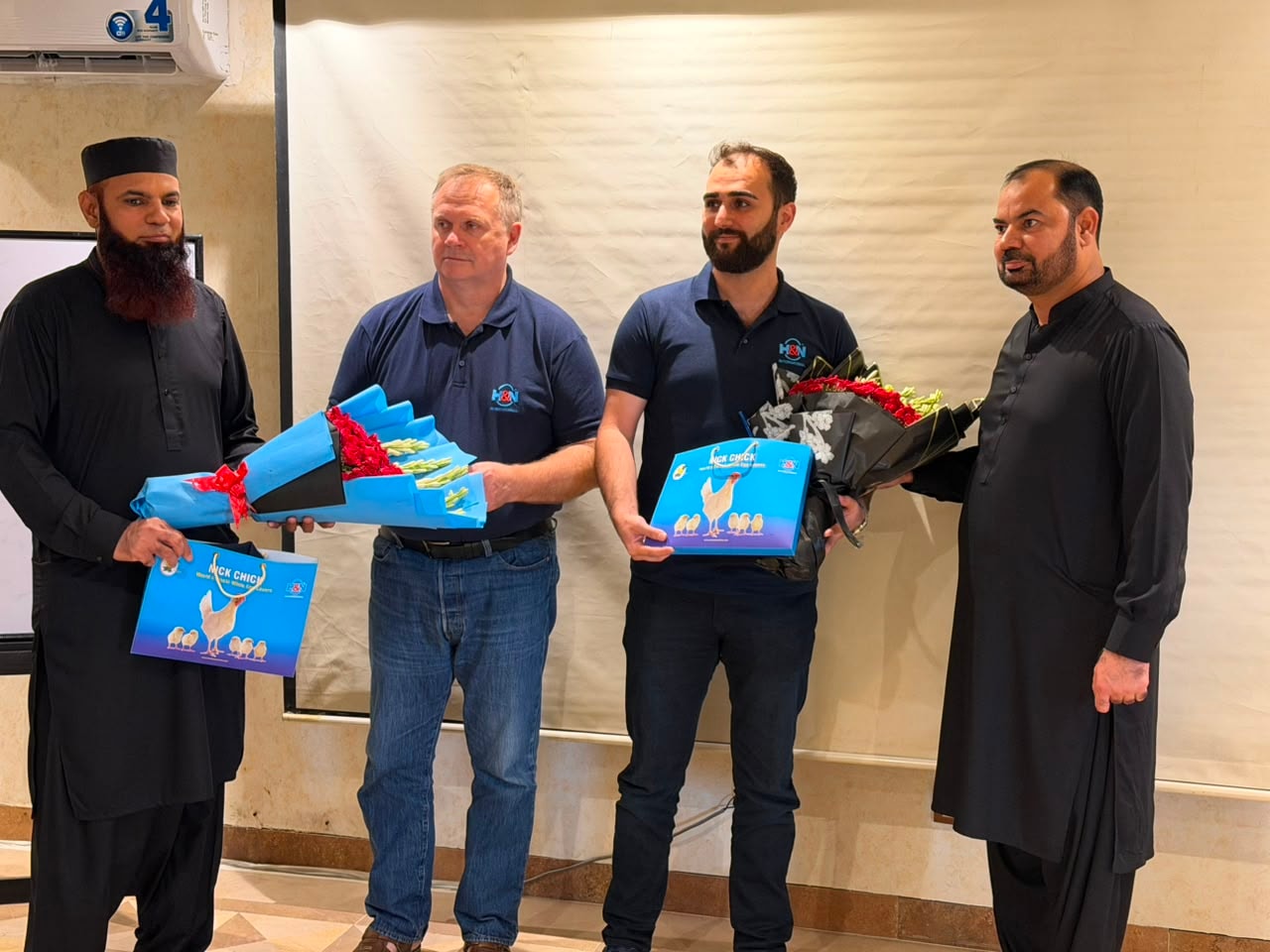 Workshop ceremony — speakers and team members presenting bouquets and management guides